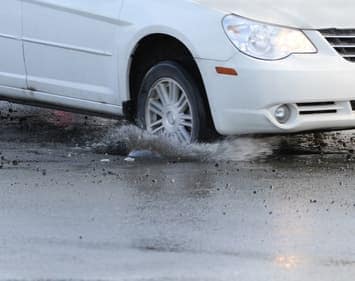 Car Passenger Tire Running Over Pothole